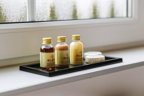 three bottles of honey on a tray on a window sill at The White House in Maria-Hoop