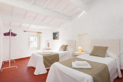 a white room with two beds in it at ROQUES 24 in Ciutadella