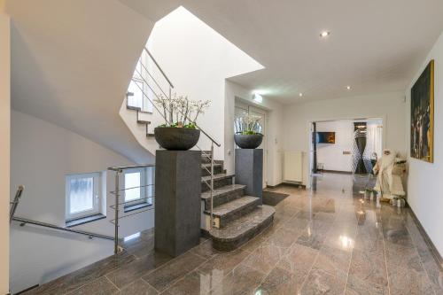 a staircase in a house with two vases at The White House in Maria-Hoop