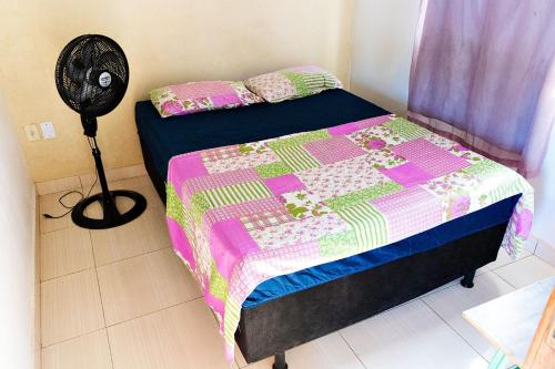 1 dormitorio con 1 cama con edredón y ventilador en Casa com Churrasqueira e Piscina em Camacari BA, en Camassari