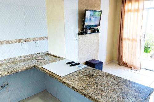 Habitación de hotel con barra y TV en la pared en Casa com Churrasqueira e Piscina em Camacari BA, en Camassari