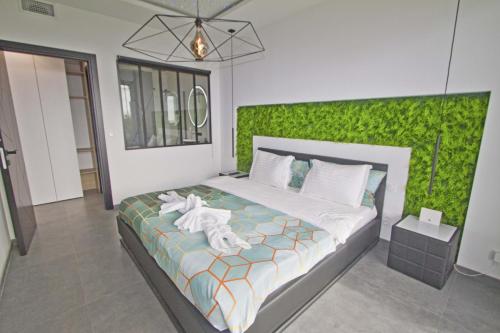 a bedroom with a bed with a green wall at Luxury Garden Jacuzzi Promenade in Nice