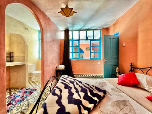 - une chambre avec un lit doté d'une couverture zébrée dans l'établissement Dar karam, à Essaouira