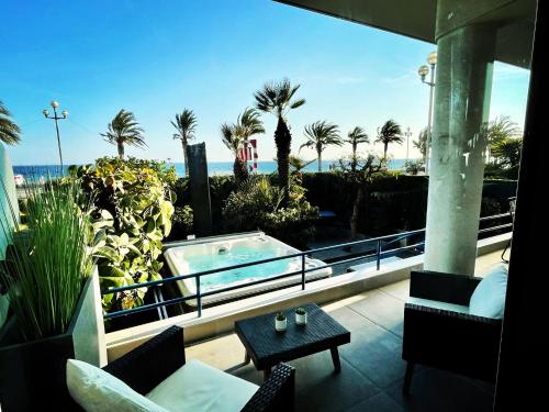 d'un balcon avec un bain à remous et une vue sur la plage. dans l'établissement Luxury Garden Jacuzzi Promenade, à Nice
