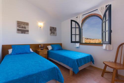 una camera da letto con due letti e una finestra di Villa Lira a Cala Morell