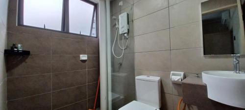 ein Badezimmer mit einem WC, einem Waschbecken und einem Spiegel in der Unterkunft HOMESTAY 2 ARC @ AUSTIN HILLS JB in Johor Bahru