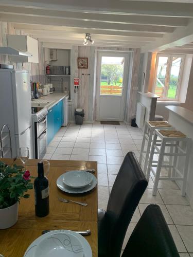 a kitchen with a table and chairs and a dining room at Swift Gites Creuse in Ventenat