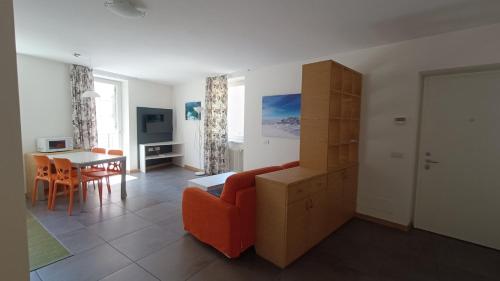 een woonkamer met een rode bank en een tafel bij Casa Cappello in Malè