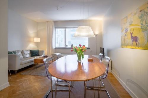 ストックホルムにあるStockholm Checkin Apartment Alvikのリビングルーム(テーブル、椅子、ソファ付)