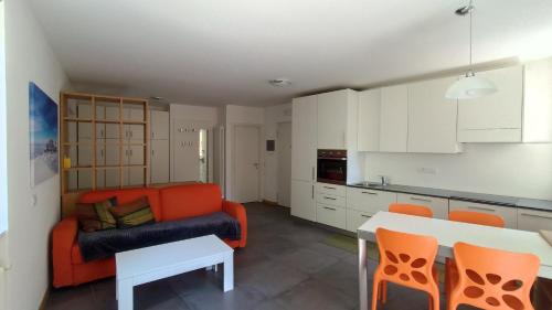 een woonkamer met een oranje bank en een tafel bij Casa Cappello in Malè