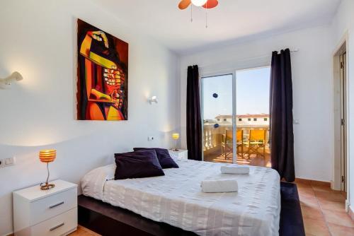 a bedroom with a bed and a large window at Villa Fiesta in Ciutadella