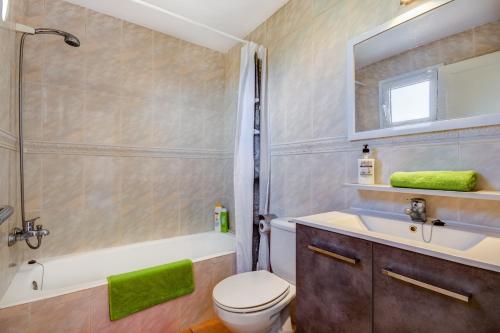 a bathroom with a toilet and a sink and a tub at Villa Fiesta in Ciutadella