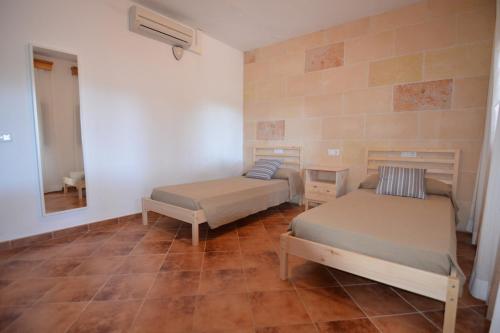 a room with two beds and a mirror at Villa S'Hortal in Ciutadella