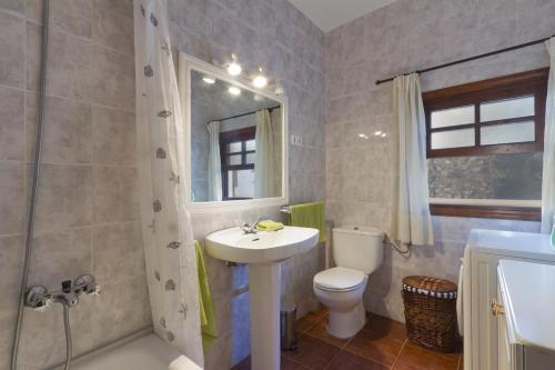 La salle de bains est pourvue d'un lavabo, de toilettes et d'une douche. dans l'établissement Villa S'Hortal, à Ciutadella