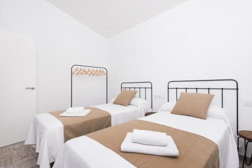 シウタデリャにあるSa Casetaの白い壁の客室内のベッド2台