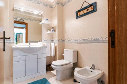 ein weißes Bad mit einem WC und einem Waschbecken in der Unterkunft Baleal Beachfront Apartment in Ferrel