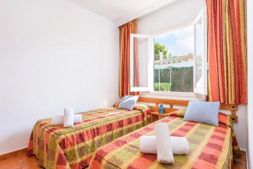 two beds in a room with a window at Duna Villa, Cala Blanca in Cala Blanca