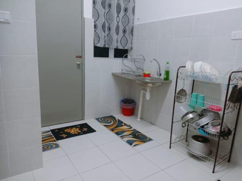 關丹的住宿－HOMESTAY KUANTAN INDERA SEMPURNA 2，白色的浴室设有水槽和淋浴。