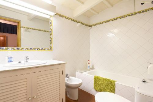 a bathroom with a sink and a tub and a toilet at SA FONT in Ciutadella