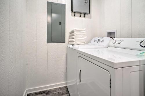 a white bathroom with a sink and a mirror at Broken Bow Cabin on 15 Acres with Stocked Fish Pond! in Broken Bow