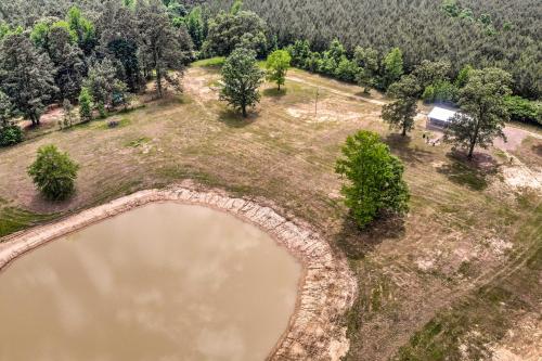 an aerial view of a pond in a field with trees at Broken Bow Cabin on 15 Acres with Stocked Fish Pond! in Broken Bow