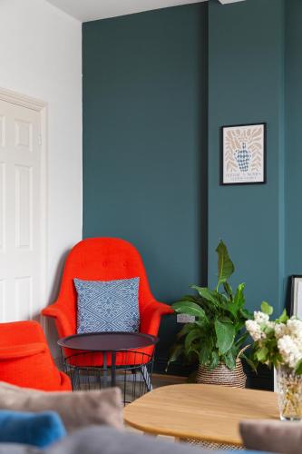 a room with two red chairs and a table at Albany by Black Door Stays in Cardiff