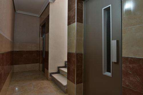 a bathroom with stairs and a shower with brown tiles at Apartamento Gregorio in Torrevieja