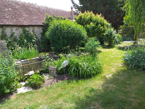 um jardim com arbustos e plantas em frente a uma casa em Chambres d'hôtes, " au coeur de la nature, et du calme" em Descartes