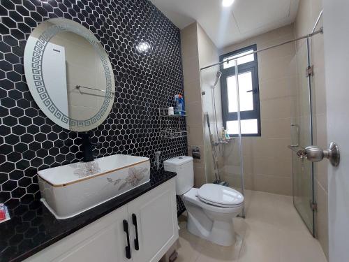 a bathroom with a toilet and a sink and a mirror at CĂN HỘ CAO CẤP CÓ SÂN VƯỜN TẠI BIÊN HÒA in Bien Hoa