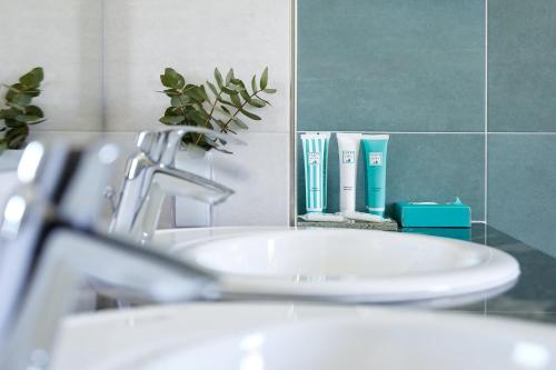 a bathroom sink with a faucet and a mirror at Golden Hotel in Marina di Cecina