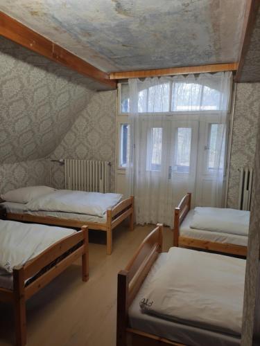 a room with three bunk beds and a window at středisko Doubrava in Zlaté Hory