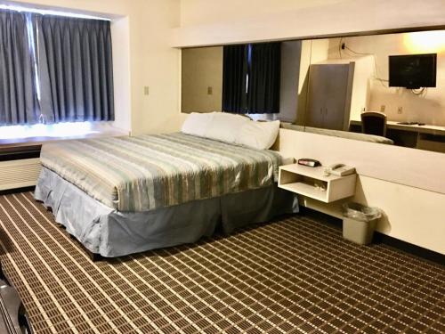 a hotel room with a bed and a television at Chadron Inn & Suites in Chadron