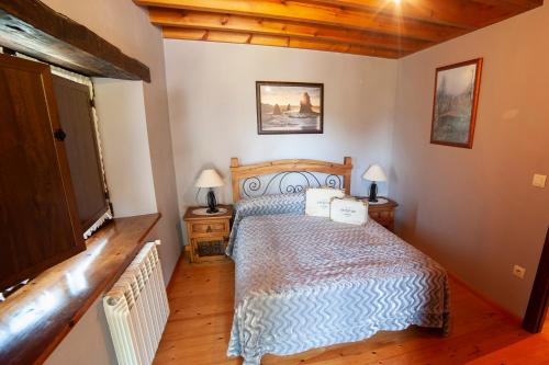 1 dormitorio con 1 cama en una habitación con suelo de madera en Casa Campu 2, en Pandavenes