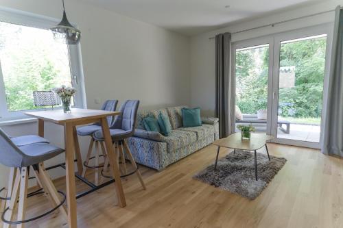 a living room with a couch and a table and chairs at Apartments Oasis Wörthersee neu & zentral in Krumpendorf am Wörthersee