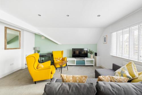 a living room with a couch and chairs and a tv at Albany by Black Door Stays in Cardiff
