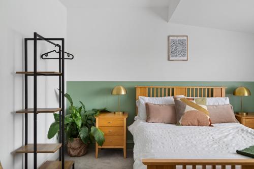 a bedroom with a bed and a desk with a plant at Albany by Black Door Stays in Cardiff