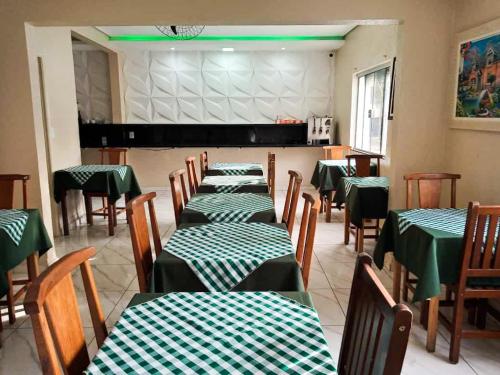 a dining room with green and white tables and chairs at Hotel Rio Claro in Rio Claro