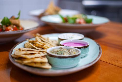 a table with plates of food with dip and chips at STAY Rhodes Hotel in Rhodes Town