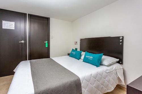 1 dormitorio con 1 cama grande con almohadas azules en Ayenda Agustin Plaza, en Pasto