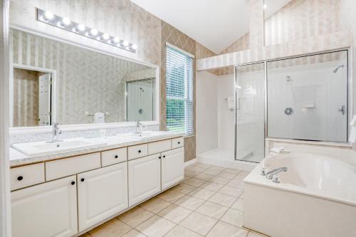 a bathroom with two sinks and a tub and a shower at Golf Course Estates in Davenport
