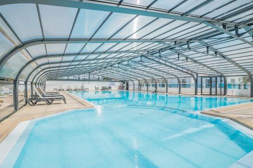 une grande piscine intérieure avec un plafond dans l'établissement Vacances à 6 dans un Domaine avec piscine chauffée, à Bretignolles-sur-Mer