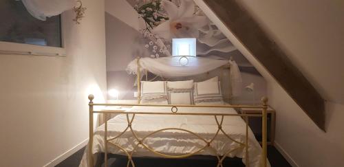 une chambre avec un lit avec des oreillers blancs dessus dans l'établissement Le Moulin d'Airou au cœur de la Baie du Mont Saint Michel, à Rouffigny