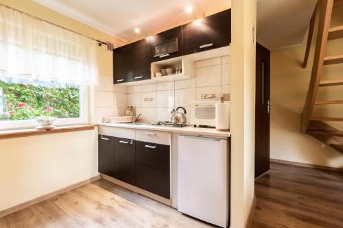 una cocina con electrodomésticos en blanco y negro y una ventana en Domek pod Orzechem, en Kudowa-Zdrój