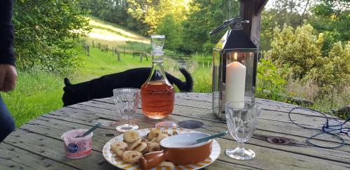 - une table avec une assiette de nourriture et une bouteille d'alcool dans l'établissement Le Moulin d'Airou au cœur de la Baie du Mont Saint Michel, à Rouffigny