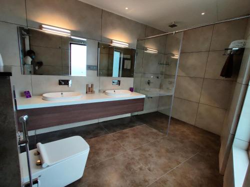 a bathroom with two sinks and a shower at Florida Airport Hotel Kochi in Nedumbassery