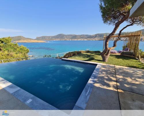 a swimming pool with a view of the water at Villa PortoMare in Porto Rafti