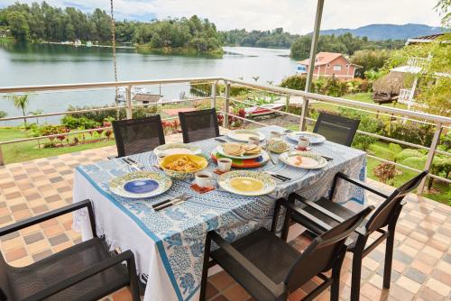 a table with food and a view of a river at Hotel Bania travels in Guatapé