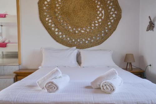 a bedroom with a white bed with two towels on it at XALAKAS SUMMER HOUSE in Empourios