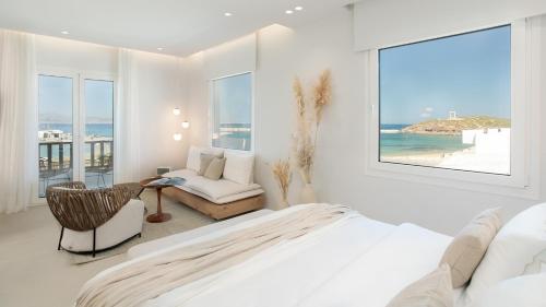 a bedroom with a bed and a chair and a window at Porta Marina in Naxos Chora