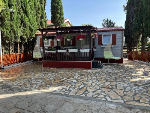 a patio with a gazebo with chairs and a table at Apartments and bungalows vila Dalibor in Nin